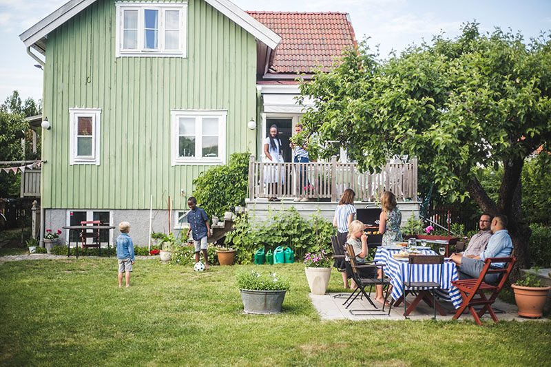 Grön villa med familj som grillar