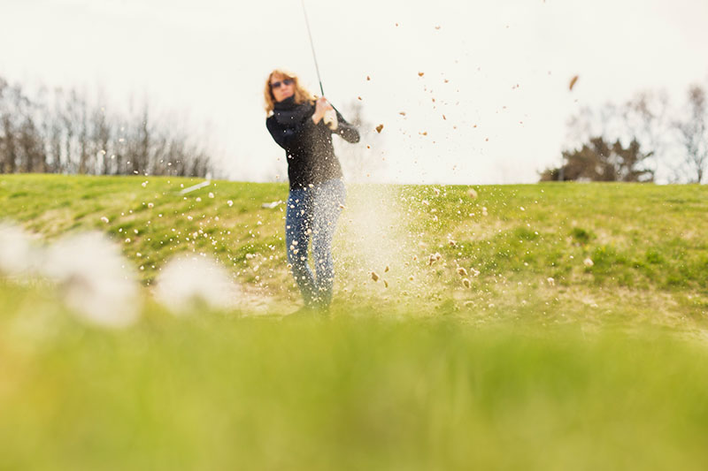 Kvinna som spelar golf
